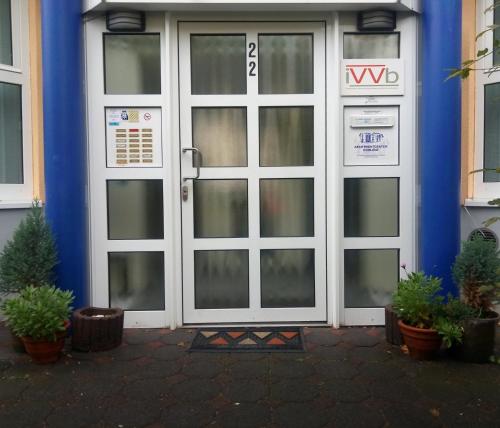 une paire de portes avec des plantes devant un bâtiment dans l'établissement Apartmentcenter Koblenz, à Coblence