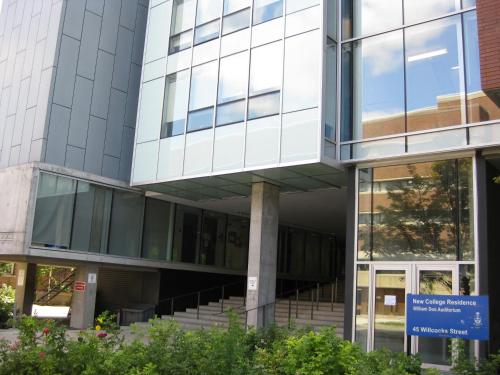 an office building with a blue sign in front of it at University of Toronto-New College Residence-45 Willcocks Residence in Toronto