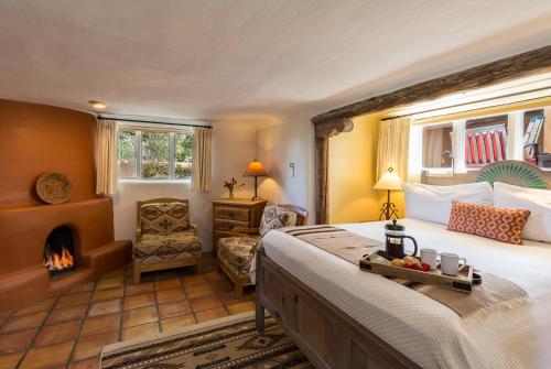 1 dormitorio con 1 cama grande y chimenea en Inn of the Turquoise Bear, en Santa Fe