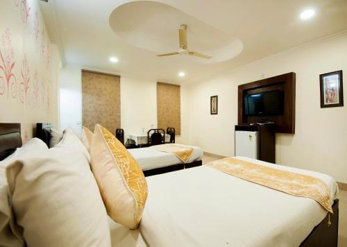 ニューデリーにあるHOTEL DAKHA INTERNATIONAL - Karol Bagh, New Delhiのベッド2台とテレビが備わるホテルルームです。