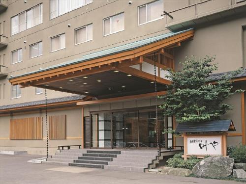 ein Gebäude mit einer Treppe vor einem Gebäude in der Unterkunft Itoen Hotel Iizakakanouya in Fukushima