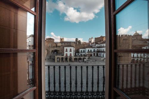 een open raam met uitzicht op de stad bij Apartamentos Soho Boutique Plaza Mayor Caceres in Cáceres