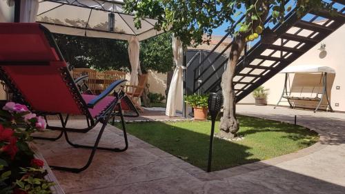 a chair and a tree in a yard at Artista B&B in Càbras