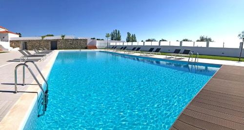 una grande piscina con acqua blu e sedie di Varchotel a Elvas