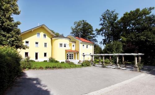 Una gran casa amarilla con una gran entrada en Haus Hildegunde, en Bad Füssing