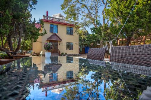 une maison avec une réflexion dans l'eau d'une piscine dans l'établissement Nordic Memory in Qingdao, à Qingdao