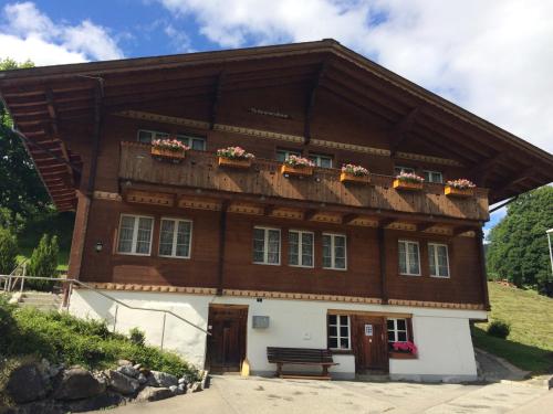 budynek z balkonem z kwiatami w obiekcie Chalet Verbrunnenhaus Grindelwald w mieście Grindelwald