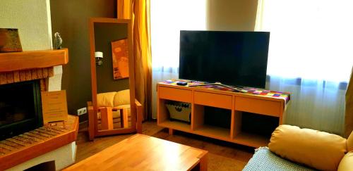 een woonkamer met een flatscreen-tv en een bank bij Gustav House in Daugavpils