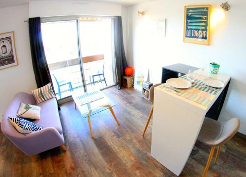 a living room with a kitchen with a table and chairs at Grand Studio Vue Mer in Douarnenez