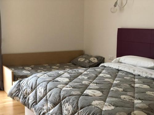 una camera con un grande letto e un cuscino e un letto sqor di Hotel Pramaggiore a Forni di Sotto