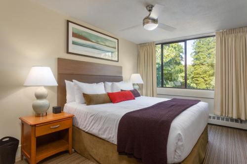 Un pat sau paturi într-o cameră la West Coast Suites at UBC