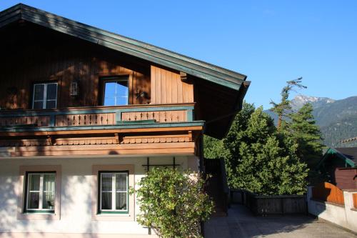 a house with a balcony on top of it at Ferienwohnung Seilbahn in Sankt Gilgen