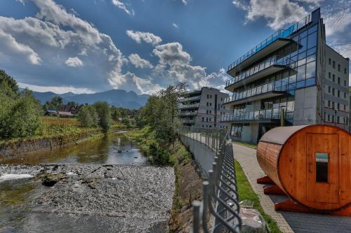 un bâtiment à côté d'une rivière à côté d'un bâtiment dans l'établissement Szklane Domy, à Zakopane