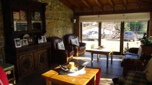 een woonkamer met lederen stoelen en een tafel bij Posada Herrán in Santillana del Mar