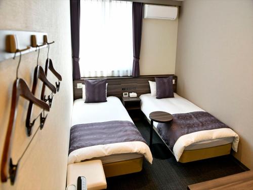 New Commander Hotel Osaka Neyagawa में एक कमरे में एक या कई बेड