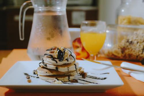 a plate of ice cream on a table with a glass of orange juice at Hotel Marfil in San Antonio