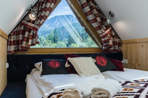 Cama en habitación con ventana grande en Rezydencja Sobiczkowa Apartamenty, en Zakopane