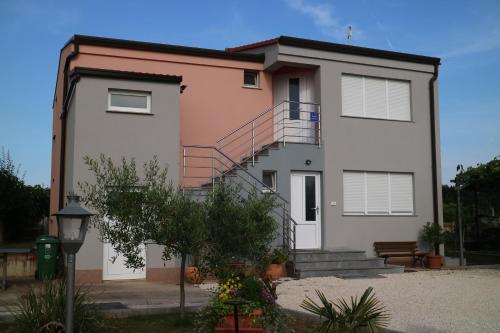 een wit huis met een trap ervoor bij Apartment Ivano in Fažana