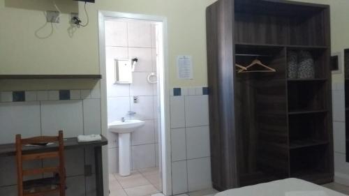 een badkamer met een wastafel, een toilet en een douche bij Ville House Hotel Canoas in Canoas