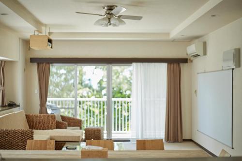 a living room with a couch and a large window at Scallop Beach Condominium in Onna