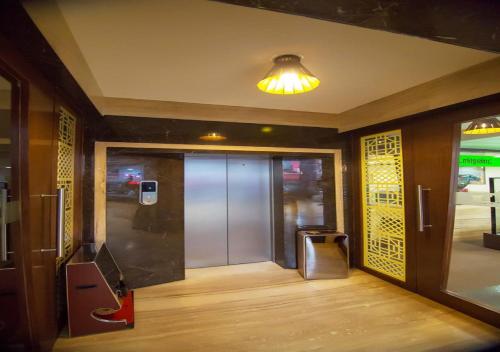 a hallway with a glass door and a light at Hotel iStay in Coimbatore