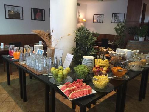 een tafel met veel fruitschalen erop bij Hotel Datini in Prato