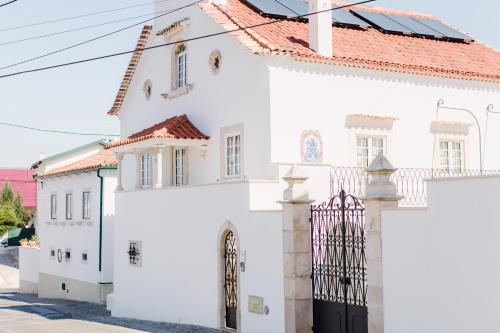 una casa bianca con un cancello davanti di Sra da Oliveira Solar Heritage a Leiria