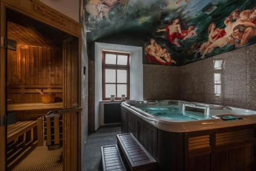 een badkamer met een bad en een schilderij aan de muur bij Chateau Krakovany in Krakovany