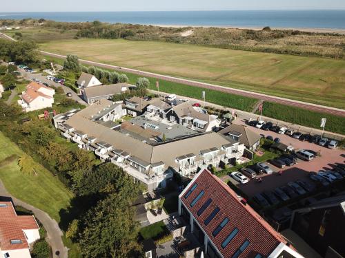 een luchtzicht op een groot huis met een parkeerplaats bij Hotel Restaurant 't Klokje in Renesse