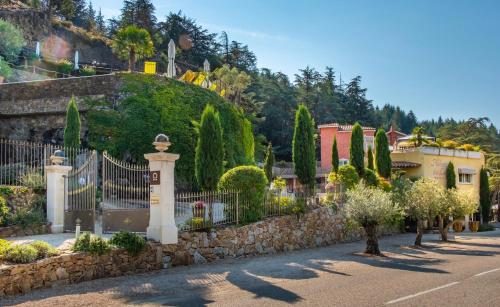 una strada in un villaggio con recinzione e alberi di Auberge Du Lac a Saint-Marcel-lès-Annonay