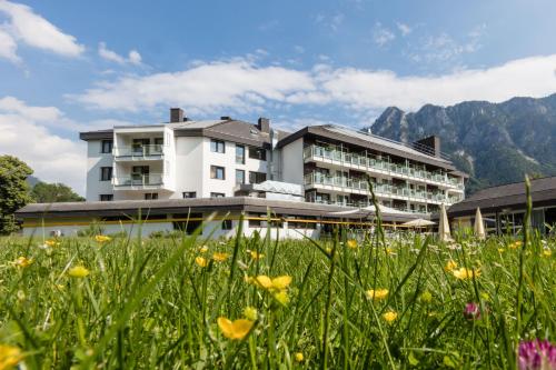 un hotel in montagna con un campo di fiori di Parkhotel Hirschwang a Reichenau