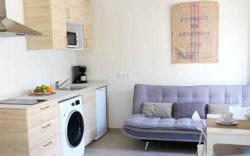 a living room with a purple couch in a kitchen at Apartamentos Plaza Mayor in Gijón