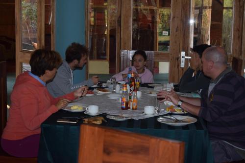 een groep mensen die rond een tafel zitten te eten bij Roika Tarangire Tented Lodge in Kwa Kuchinia