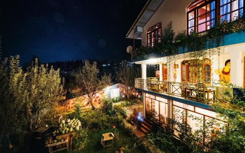 a view of a building with a garden at night at Orchards House - The Hidden Tribe in Manāli