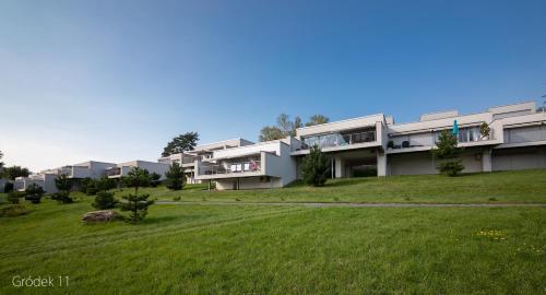 un gran edificio con un campo verde delante de él en Apartment Słoneczny Gródek 11, en Gródek Nad Dunajcem