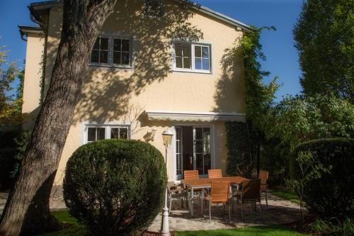 uma casa com uma mesa e cadeiras em frente em Villa Maxglan em Salzburgo