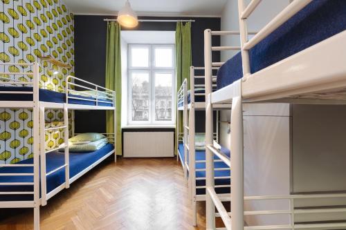 a room with two bunk beds and a window at Atlantis Hostel in Kraków