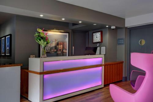 un bar con illuminazione viola in una sala d'attesa di Heywood House Hotel, BW Signature Collection a Liverpool