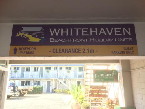 ein Schild mit weißen Strandhotels auf einem Gebäude in der Unterkunft Whitehaven Beachfront Holiday Units in Airlie Beach