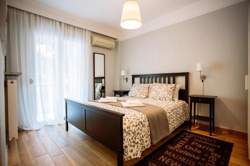 una camera con un letto e una grande finestra di Luxurious & Modern | Walk Everywhere | 5★ Amenities a Salonicco