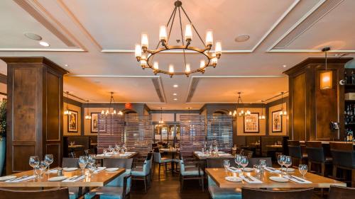 un ristorante con tavoli, sedie e lampadario a braccio di Georgian Court Hotel, WorldHotels Elite a Vancouver