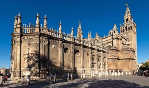 een oud stenen gebouw met een blauwe lucht op de achtergrond bij Tourist House Arenal in Sevilla