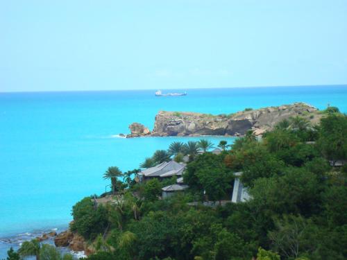 an island with a boat in the ocean at Breeze Cottage in Five Islands Village