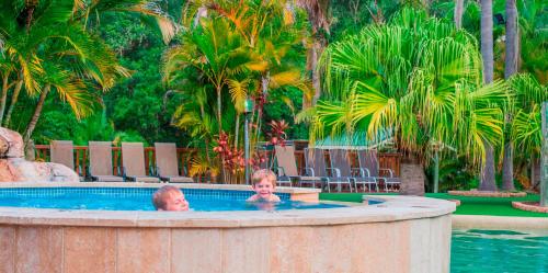 zwei Kinder in einem Pool in einem Resort in der Unterkunft The Palms At Avoca in Avoca Beach