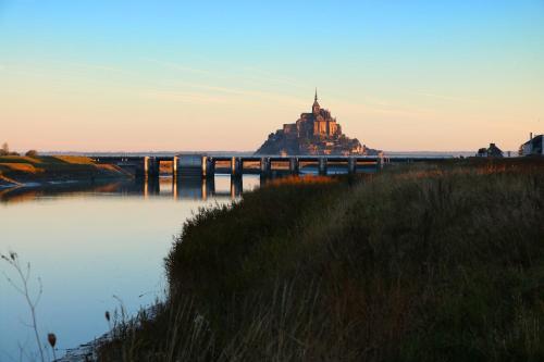 un château sur un pont sur une étendue d'eau dans l'établissement Le Mouton Blanc, au Mont-Saint-Michel