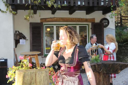 Uma mulher está a beber um copo de cerveja. em Gästehaus Weinviertel - Niederösterreich em Siebenhirten