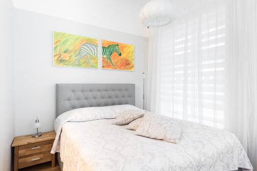 a bedroom with a bed and a painting on the wall at Kuninga City Center Apartment in Pärnu