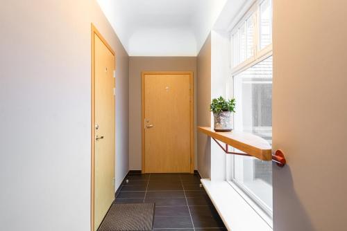 a hallway with a yellow door and a window at Kuninga City Center Apartment in Pärnu