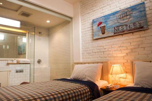 Cet appartement comprend une chambre avec deux lits et une salle de bains pourvue d'une douche. dans l'établissement Summerbird - Bed and Brasserie, à Bandung