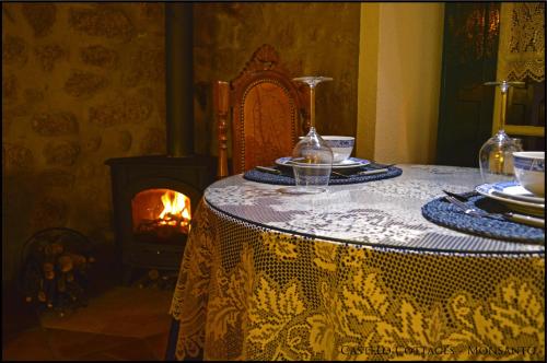 uma mesa com uma toalha de mesa e uma lareira em Castelo Cottages II em Monsanto